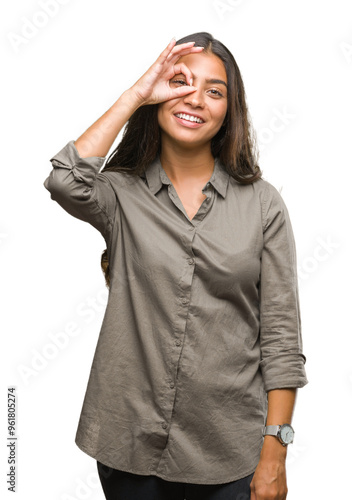 Young beautiful arab woman over isolated background doing ok gesture with hand smiling, eye looking through fingers with happy face. photo