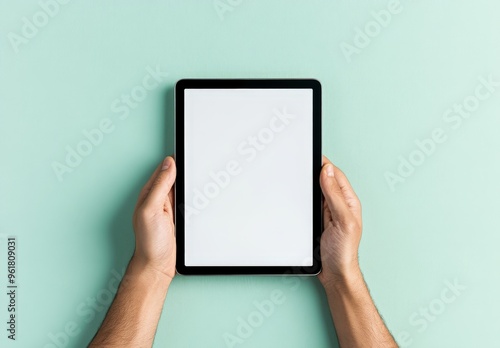 Hands holding a blank tablet on a pastel background - technology and minimalism concept