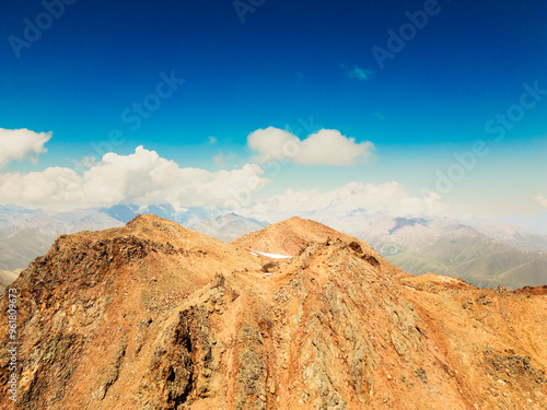 Aerial view caucasus mountains range with colorful valleys on alpine zone. Kazbek mountain peak in background photo