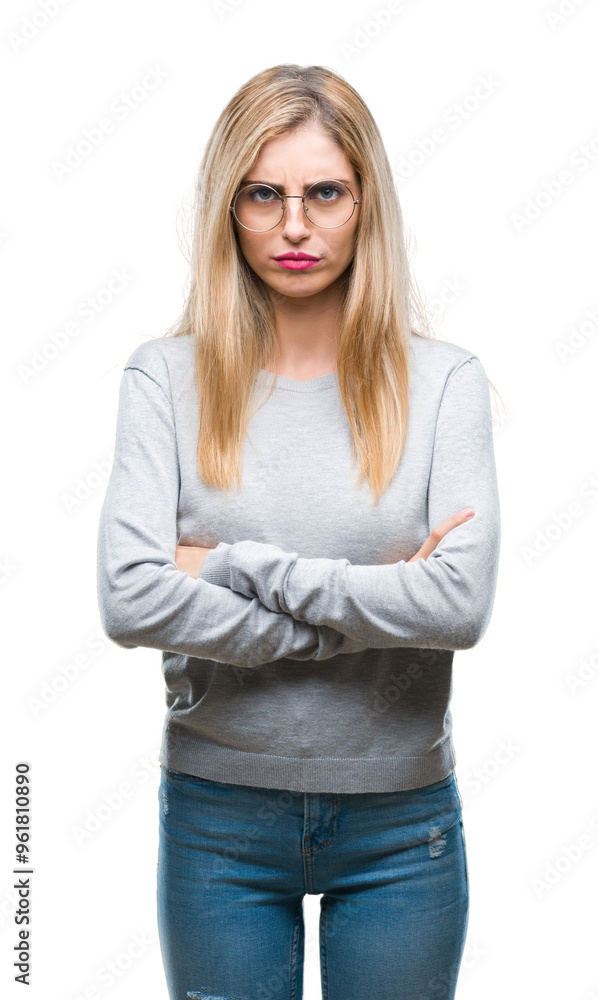 Young beautiful blonde woman wearing glasses over isolated background skeptic and nervous, disapproving expression on face with crossed arms. Negative person. Young beautiful blonde woman wearing glasses over isolated background skeptic and nervous, disapproving expression on face with crossed arms. Negative person.