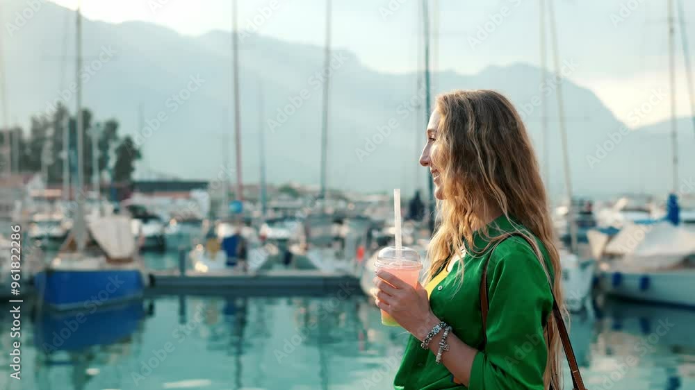 Woman enjoying a refreshing drink by a tranquil marina during golden hour Woman enjoying a refreshing drink by a tranquil marina during golden hour
