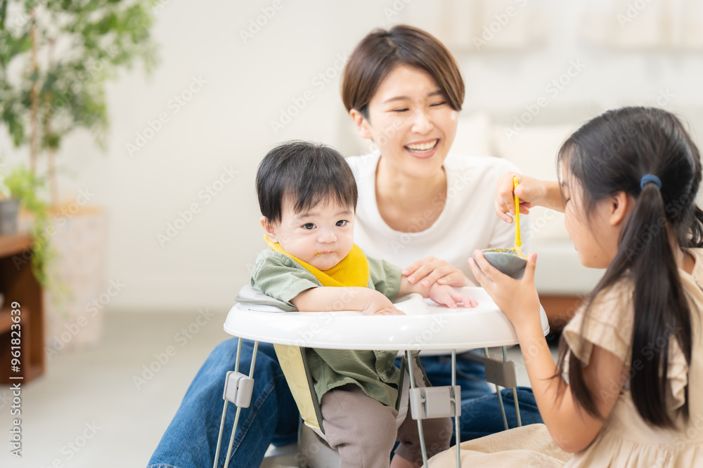 Obraz premium 0歳の弟に離乳食を与える姉