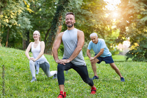 Group of people doing exercise outdoors at the park 