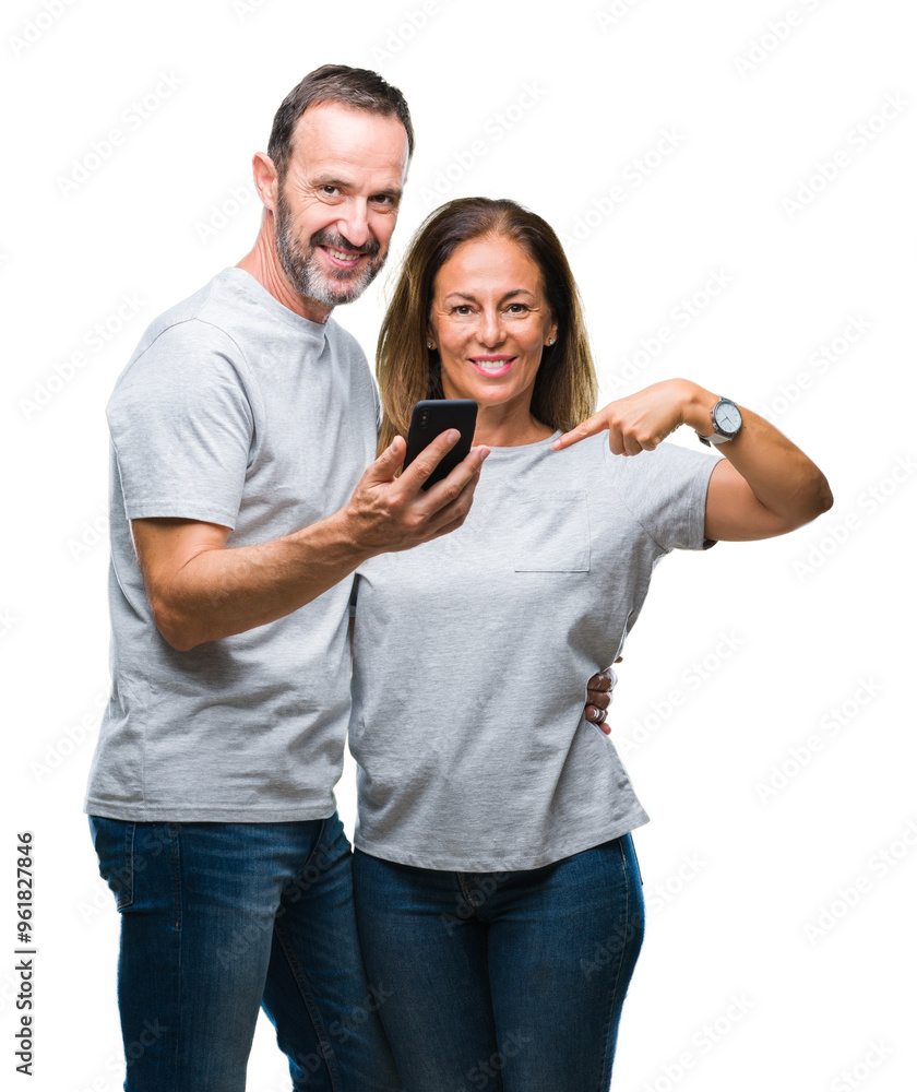 Middle age hispanic couple texting message on smartphone ver isolated background with surprise face pointing finger to himself Middle age hispanic couple texting message on smartphone ver isolated background with surprise face pointing finger to himself