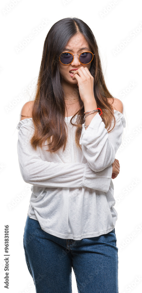 Young asian woman wearing sunglasses over isolated background looking stressed and nervous with hands on mouth biting nails. Anxiety problem. Young asian woman wearing sunglasses over isolated background looking stressed and nervous with hands on mouth biting nails. Anxiety problem.