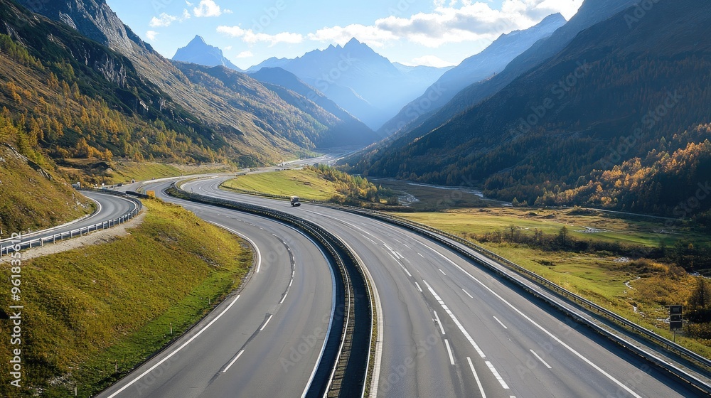 Scenic view of a motorway winding through mountains or countryside, highlighting the contrast between the road and natural scenery. Scenic view of a motorway winding through mountains or countryside, highlighting the contrast between the road and natural scenery.
