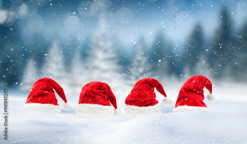 Weihnachtskarte mit Weihnachtsmützen und Schneeflocken vor unscharfem Hinterg...