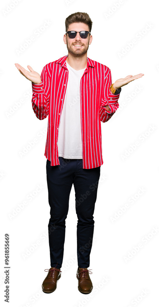 Young handsome man wearing sunglasses clueless and confused expression with arms and hands raised. Doubt concept. Young handsome man wearing sunglasses clueless and confused expression with arms and hands raised. Doubt concept.