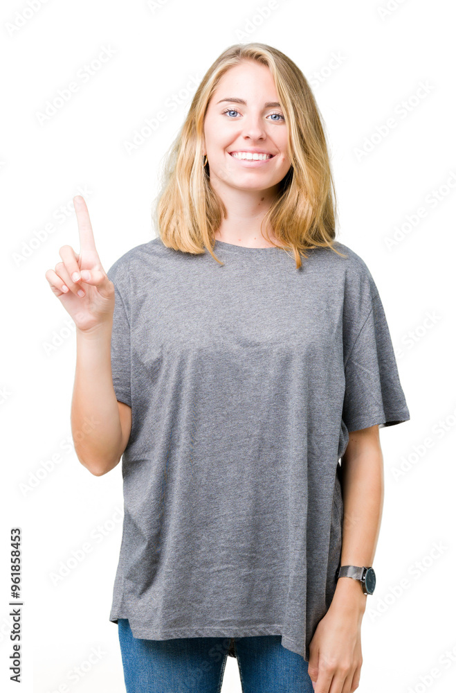 Beautiful young woman wearing oversize casual t-shirt over isolated background showing and pointing up with finger number one while smiling confident and happy. Beautiful young woman wearing oversize casual t-shirt over isolated background showing and pointing up with finger number one while smiling confident and happy.