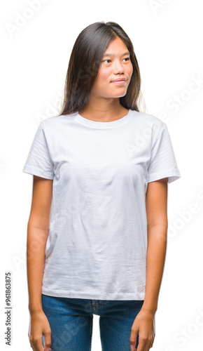 Young asian woman over isolated background smiling looking side and staring away thinking.