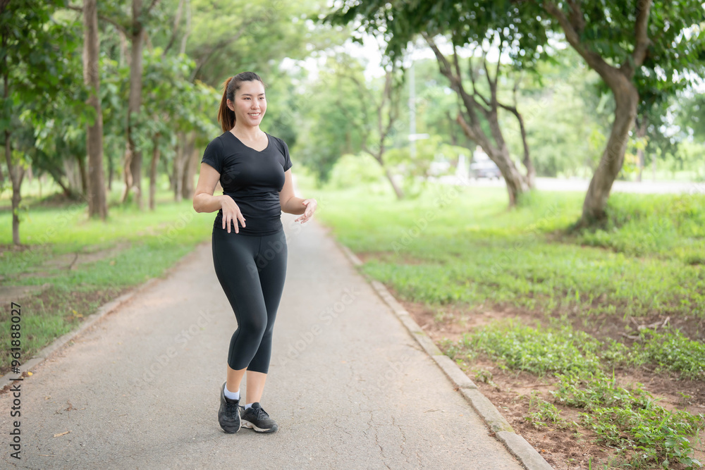 Asian woman warming up before going for a jog in a public park... Asian woman warming up before going for a jog in a public park...