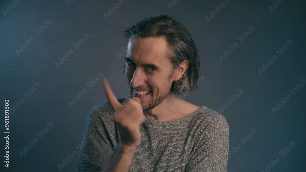 a young man
laughs, shakes his finger, shakes his head, with an expressive face with long hair is not shaved in a gray jacket on a blue gray background, medium plan a young man
laughs, shakes his finger, shakes his head, with an expressive face with long hair is not shaved in a gray jacket on a blue gray background, medium plan