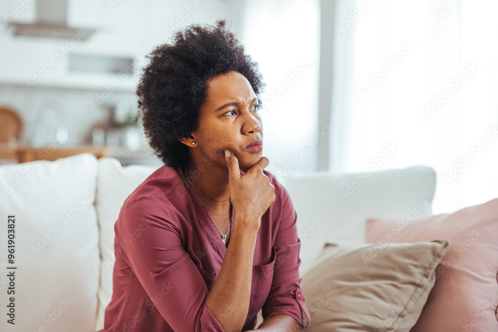 Thoughtful Woman Sitting on Couch in Contemplative Mood Thoughtful Woman Sitting on Couch in Contemplative Mood