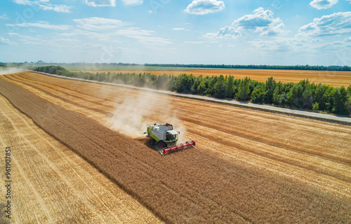 Foto Aerial view of combine harvester harvesting wheat in a field on a sunny day