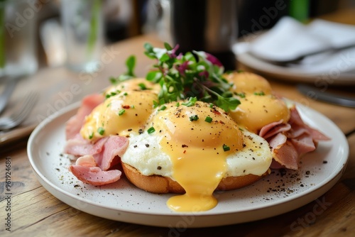 Plate with eggs benedict and ham on table