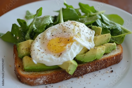 Poached eggs on toast with avocado salad for breakfast