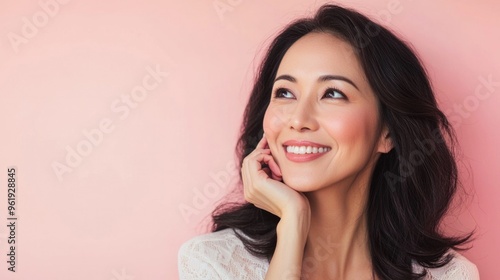 A woman with long black hair and a white shirt is smiling