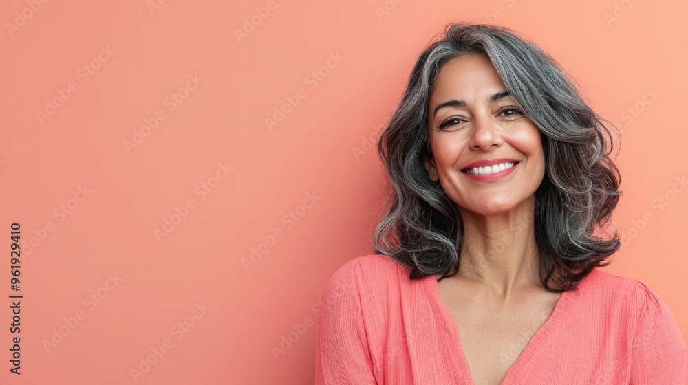 A woman with a pink shirt and gray hair is smiling A woman with a pink shirt and gray hair is smiling