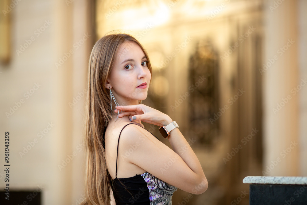 Fototapeta premium Young smiling girl walking around the city. Girl with light brown hair in summer clothes posing against the background of ancient historical buildings of Venetian style.