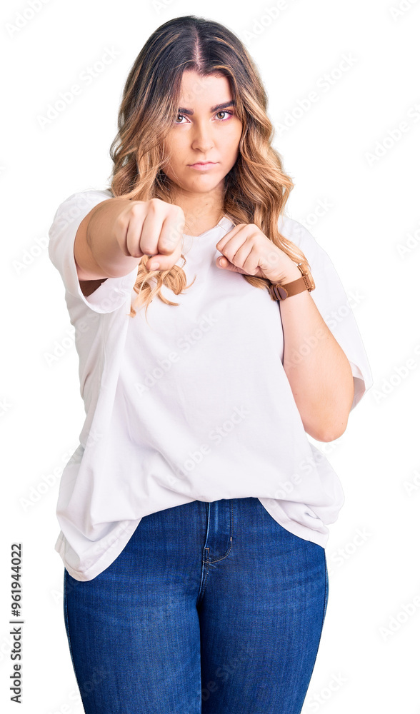 Young caucasian woman wearing casual clothes punching fist to fight, aggressive and angry attack, threat and violence Young caucasian woman wearing casual clothes punching fist to fight, aggressive and angry attack, threat and violence