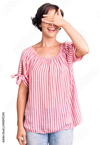 Beautiful young woman with short hair wearing casual summer clothes smiling and laughing with hand on face covering eyes for surprise. blind concept.