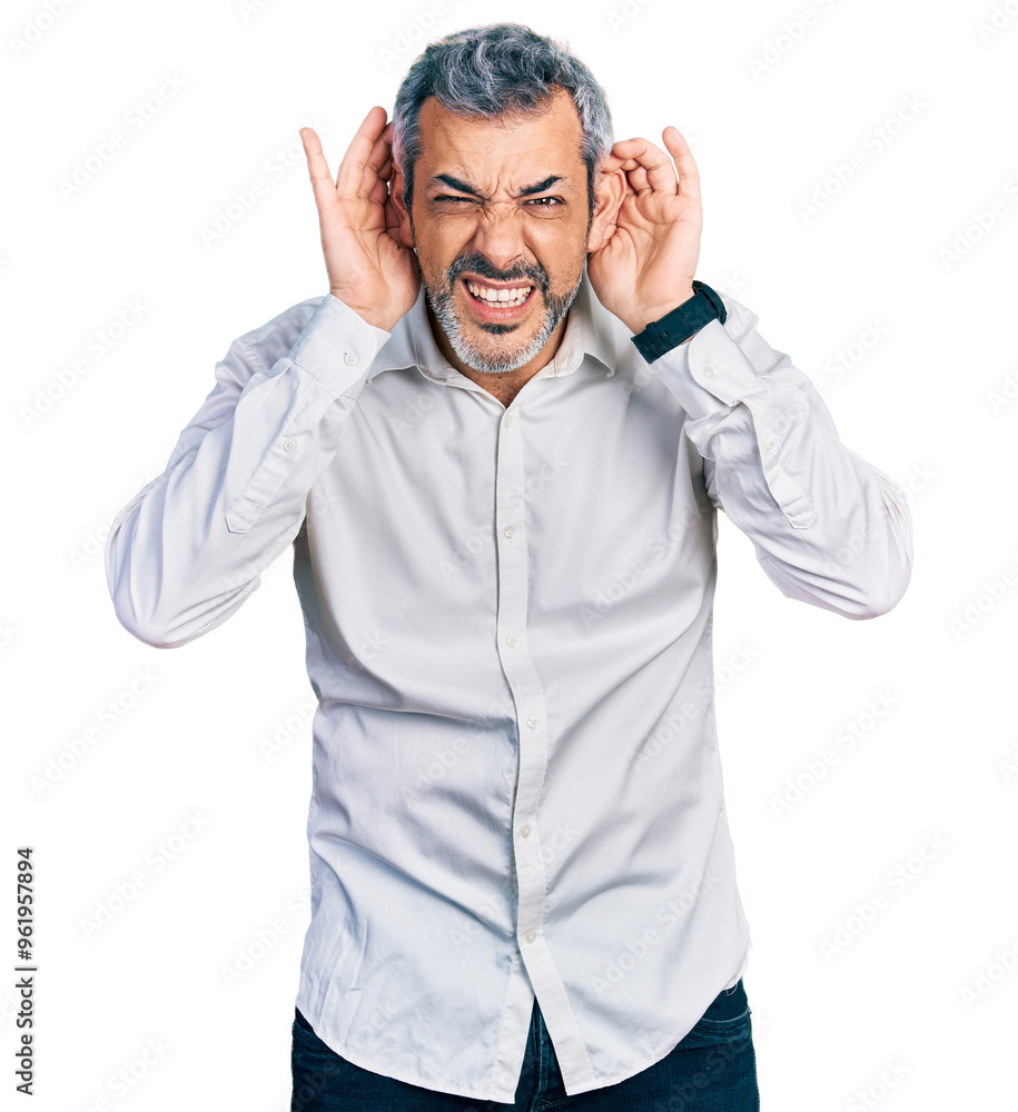 Middle age hispanic with grey hair wearing casual white shirt trying to hear both hands on ear gesture, curious for gossip. hearing problem, deaf Middle age hispanic with grey hair wearing casual white shirt trying to hear both hands on ear gesture, curious for gossip. hearing problem, deaf