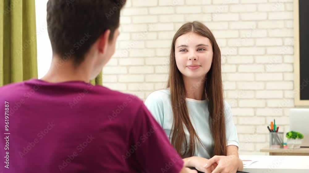 High school teenagers in classroom, girl talking with classmate after finishing exam, smiling having break. Modern education concept. High school teenagers in classroom, girl talking with classmate after finishing exam, smiling having break. Modern education concept.