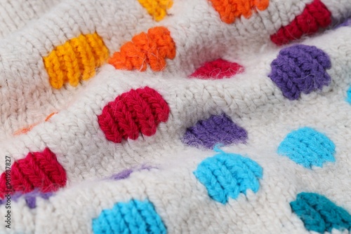 Texture of colorful knitted fabric with pattern as background, closeup