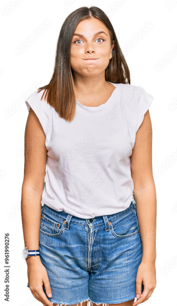 Obraz premium Young caucasian woman wearing casual white tshirt puffing cheeks with funny face. mouth inflated with air, crazy expression.