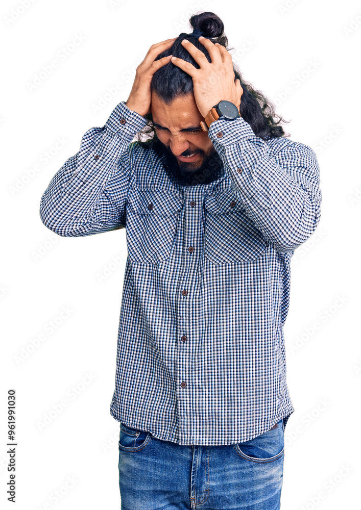 Young arab man wearing casual clothes suffering from headache desperate and stressed because pain and migraine. hands on head. Young arab man wearing casual clothes suffering from headache desperate and stressed because pain and migraine. hands on head.