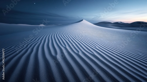 Rippling patterns of sand dunes stretch across a serene desert landscape, bathed in the gentle light of twilight, capturing the ethereal beauty of nature. photo