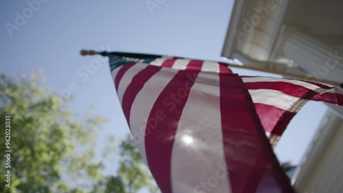 Detailed slow motion view and abstract background of the red, white, and blue American flag as it sways in the wind on a rural conservative porch on a warm, summer day in Lancaster, Ohio