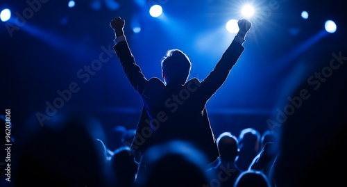 Celebrating his Business Person of the Year award, a young man leaps with excitement on stage. A dashing specialist is there, applauding and motivating him.