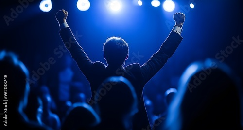 An ecstatic young man leaps on stage, celebrating his win as Business Person of the Year. He’s joined by a handsome specialist who cheers and supports him.