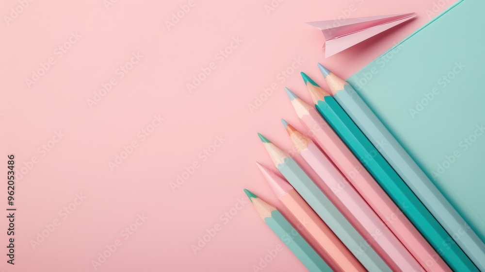 A row of colorful pencils on a pink background A row of colorful pencils on a pink background