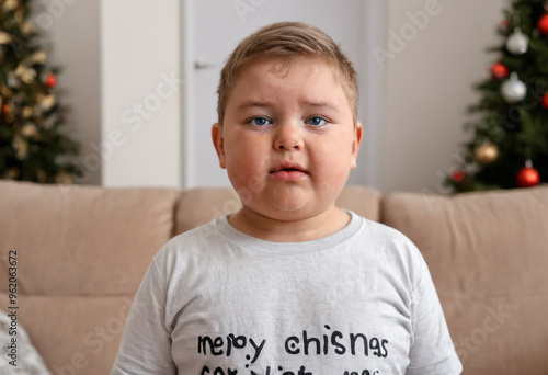 Boy, age 10, excited on Christmas morning, sitting on the couch, impatient and whiny, demanding presents. photo