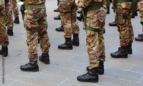 combat boots of army soldiers in camouflage uniforms standing in formation