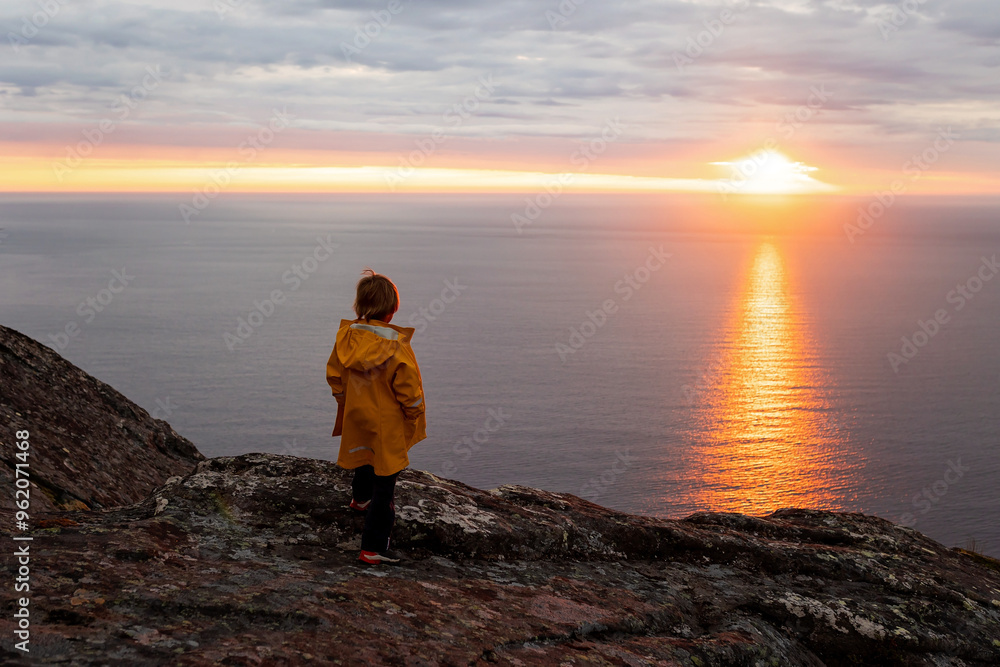 Family with children and pet, hiking Sukkertoppen trail on Senja island, Norway
