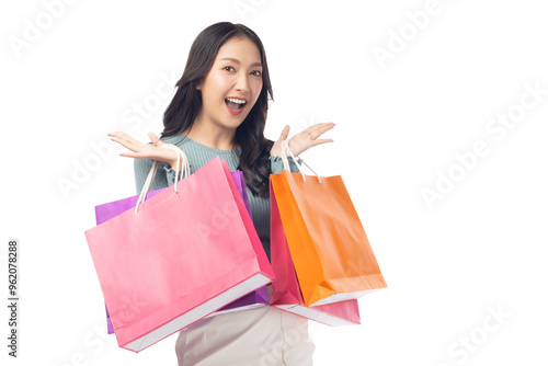 Cheerful young woman holding colorful shopping bags in both hands, expressing joy and excitement. Set against a clean white background, her enthusiasm captures the fun of a successful shopping spree