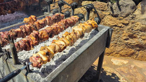 Pork lamb and chicken meat cooked traditionally on a charcoal bbq grill with charcoal. Cyprus traditional souvla food on barbecue photo