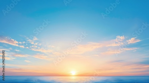 A serene sunrise over a tranquil ocean, casting soft hues of orange and pink across a clear blue sky.