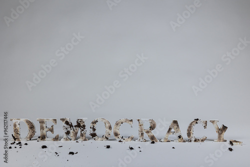 Photography Wood letters spell out democracy against white background