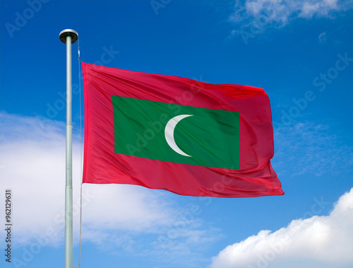 Maldives flag waving in the wind against a blue sky background photo