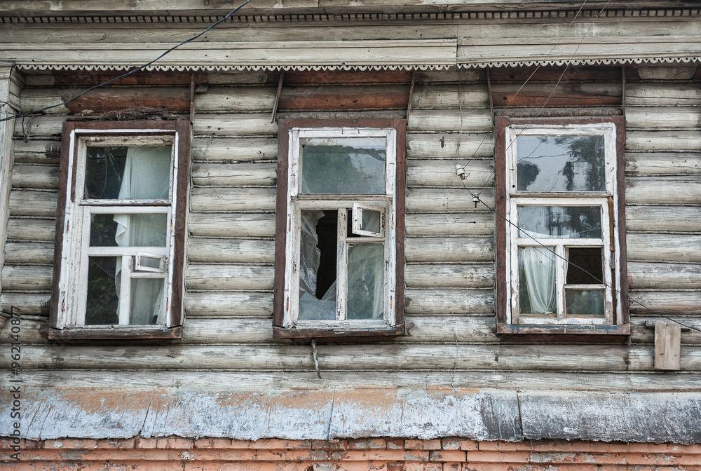 Abandoned building with shattered windows and distressed wooden exterior