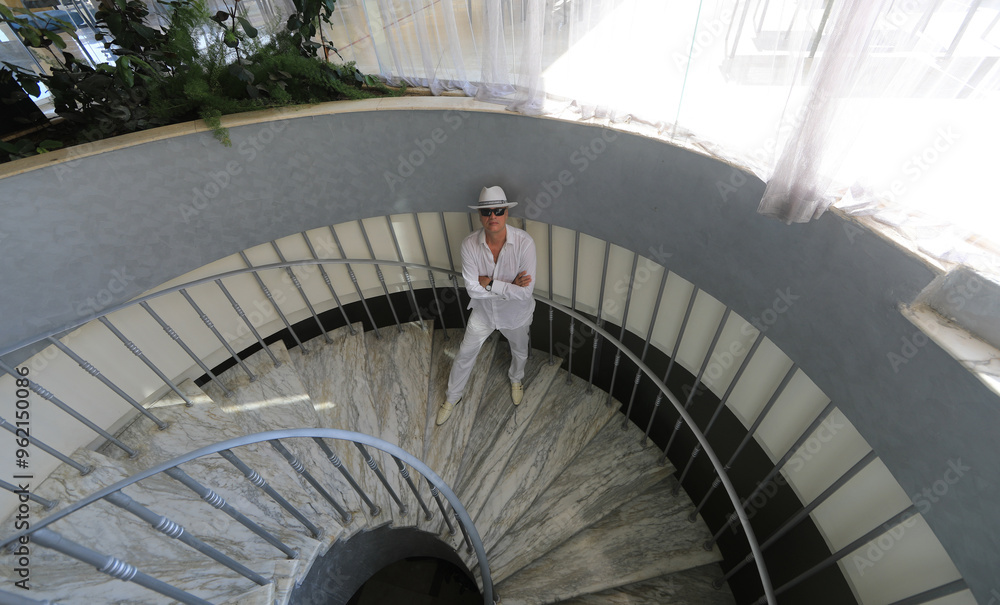 Fototapeta premium man on white spiral staircase