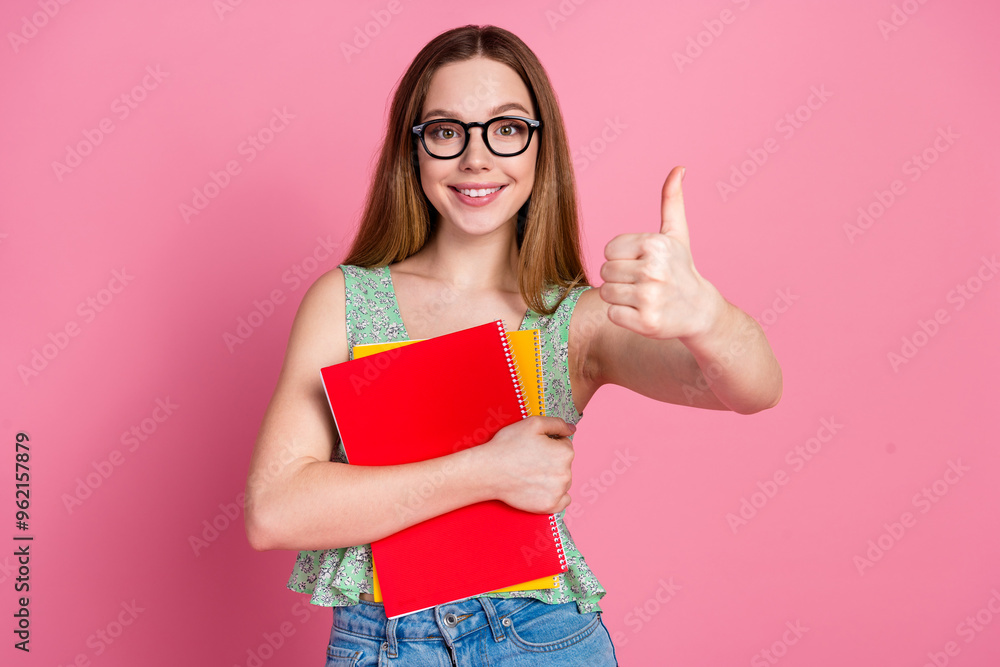 Photo of nice young girl book thumb up wear top isolated on pink color background Photo of nice young girl book thumb up wear top isolated on pink color background