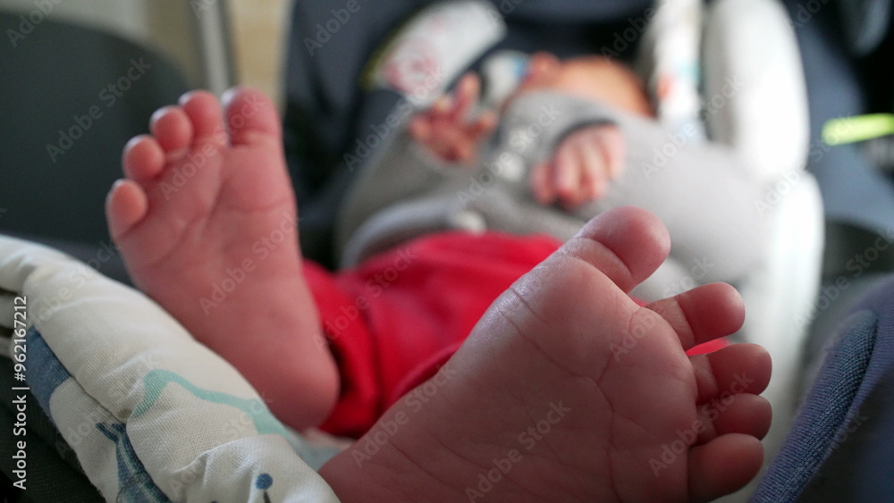 Fototapeta premium Close-up of baby’s tiny feet, soft and tender toes, relaxed infant in car seat, cozy and calm atmosphere, detailed view of newborn’s feet, intimate and loving moment, peaceful and comfortable rest