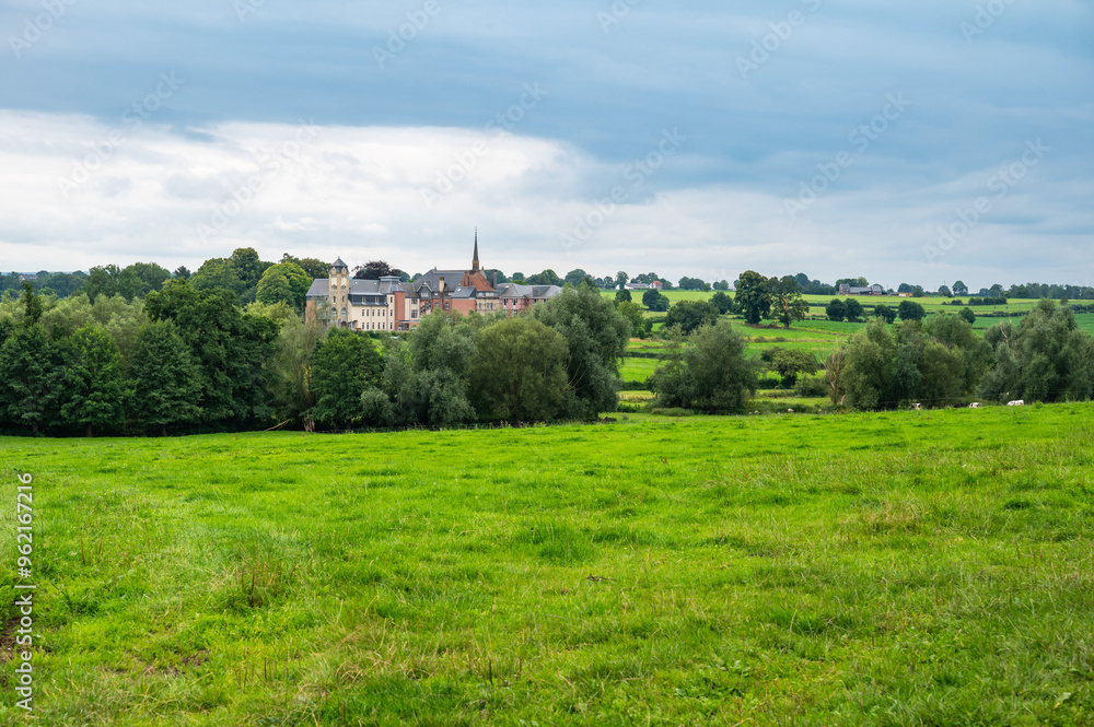 Naklejka premium Green hills and meadows at the Belgian countryside with the Chateau Thor in the background, Lontzen, Belgium