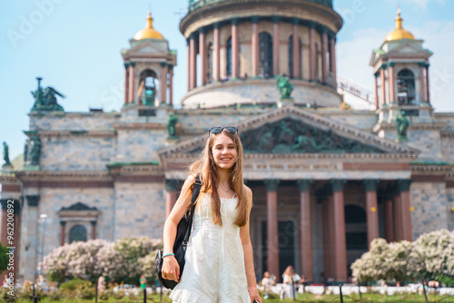 Young girl with long hair standing near St. Isaac's Cathedral in St. Petersburg. The concept of the tourist season, an active pastime.