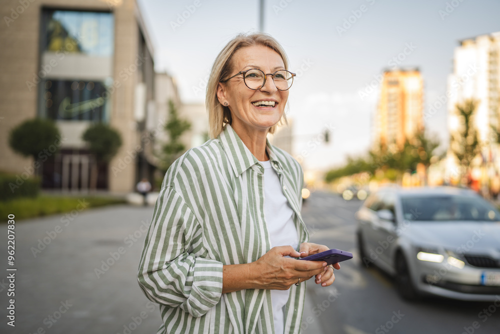 Happy mature woman stand and use mobile phone on the street Happy mature woman stand and use mobile phone on the street